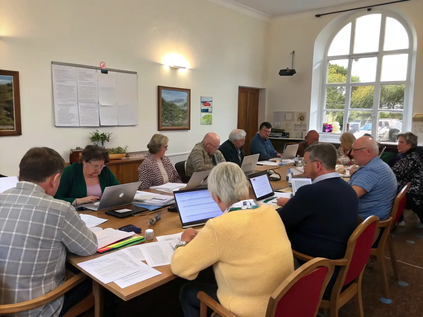 A professional photograph depicting a city council meeting in session, with diverse members collaborating around a table, symbolizing the engagement of local government in community development and procurement processes.